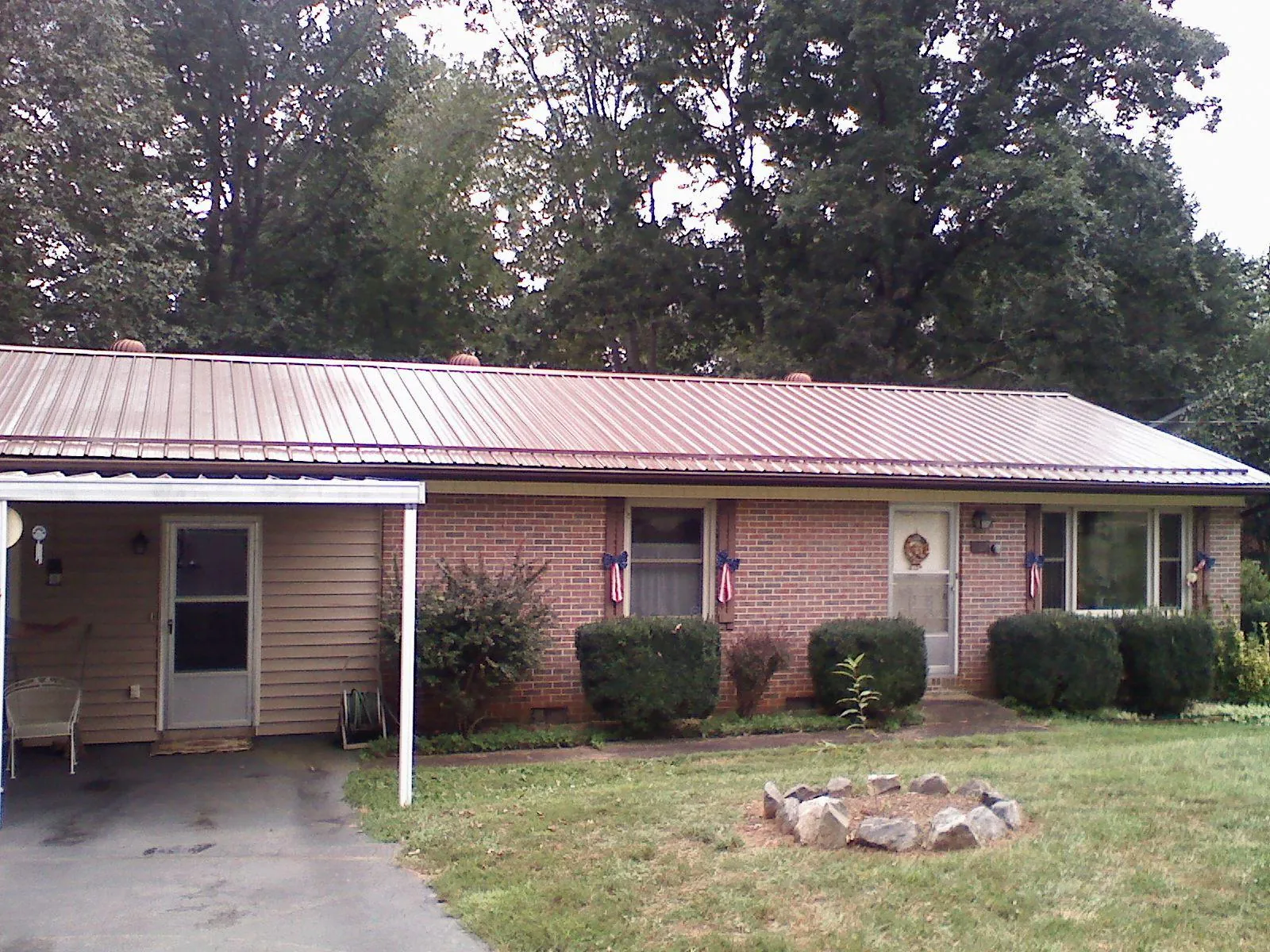 Bronze metal roof and carport on a brick ranch home — Roof Repair work by our crew in Pinewood